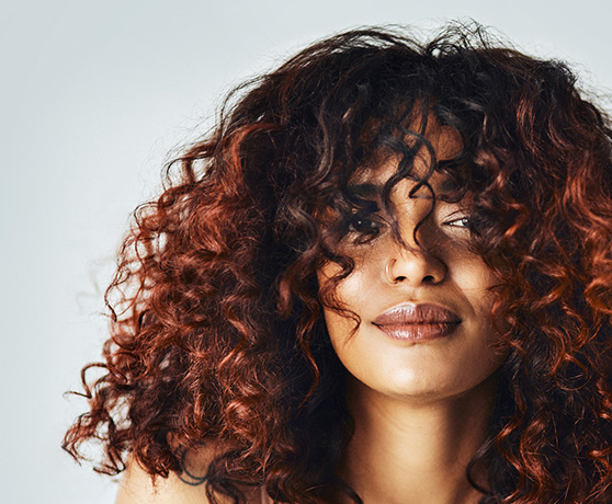 Woman with Red Balayage on Natural Curly Hair